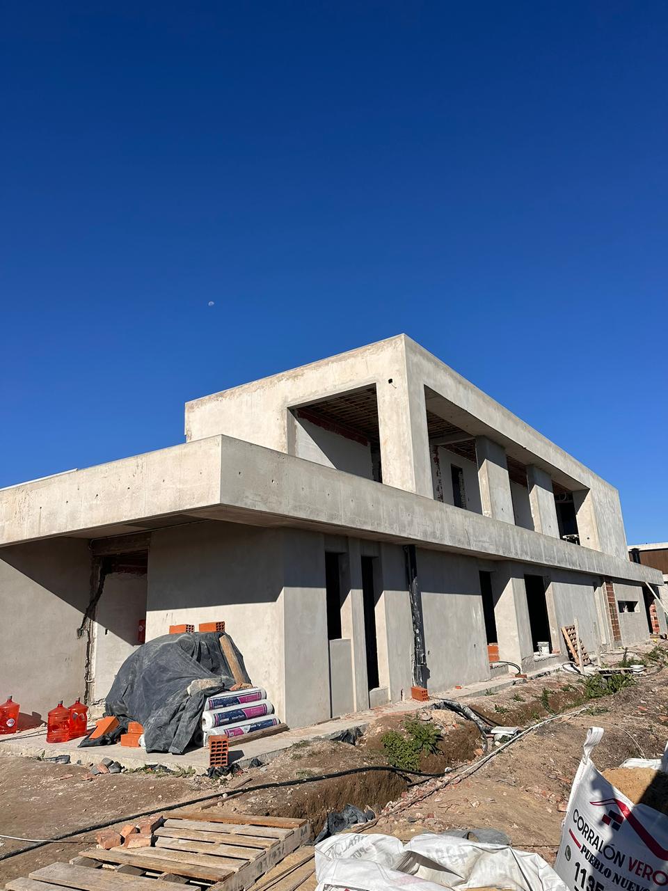 Vivienda de Casa N1 en obra, con volúmenes de hormigón visto y losa en voladizo