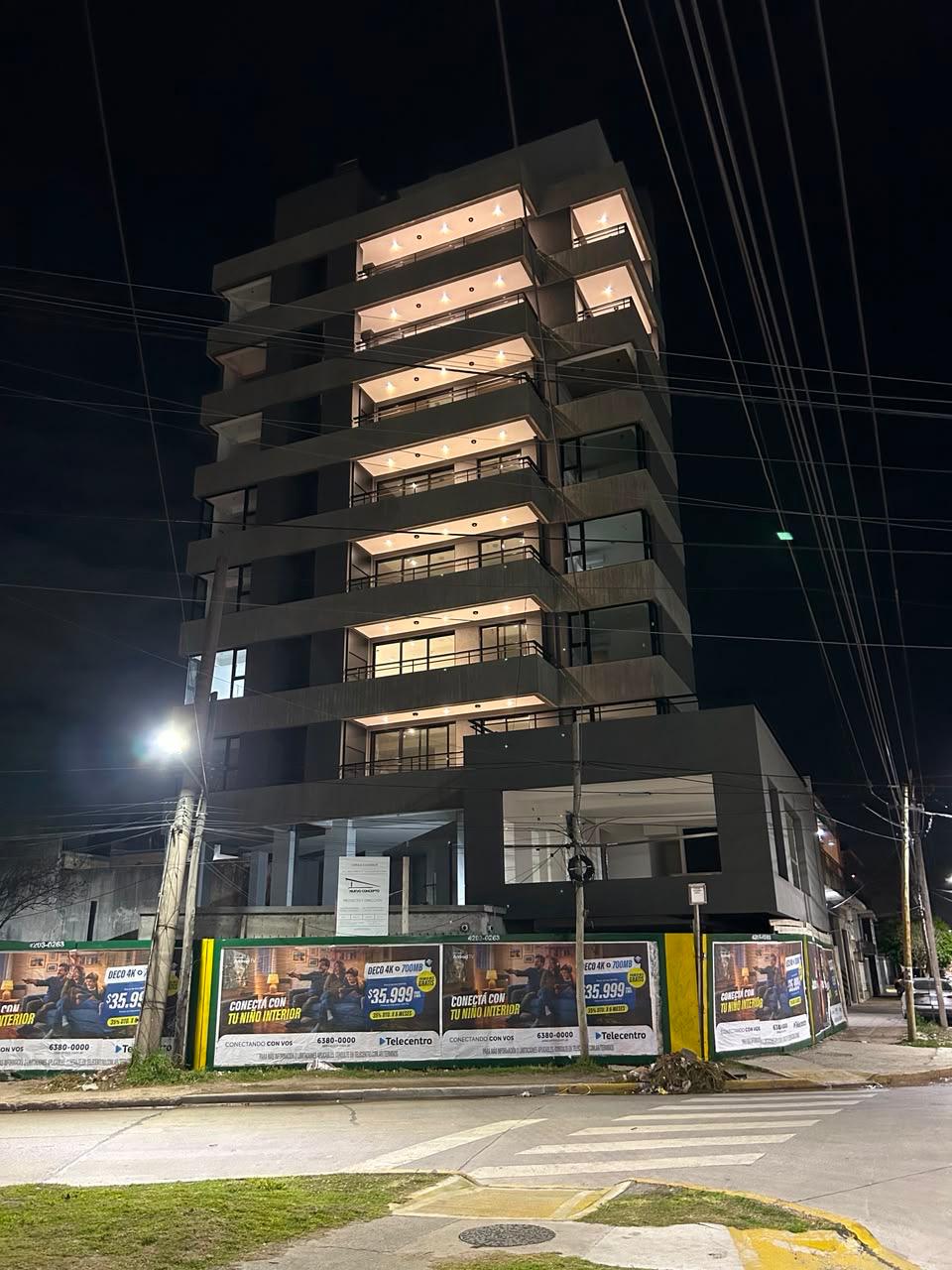 Fachada nocturna del Edificio G1 en Florencio Varela con balcones iluminados